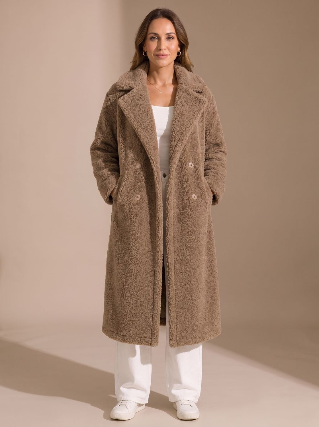 Achteraanzicht van de beige teddy coat in volle lengte