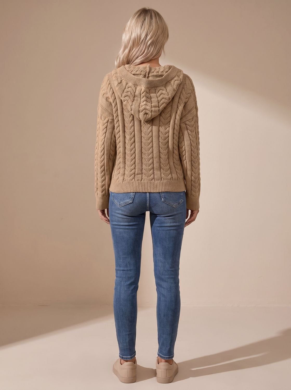Achteraanzicht van de oversized capuchontrui met kabelpatroon