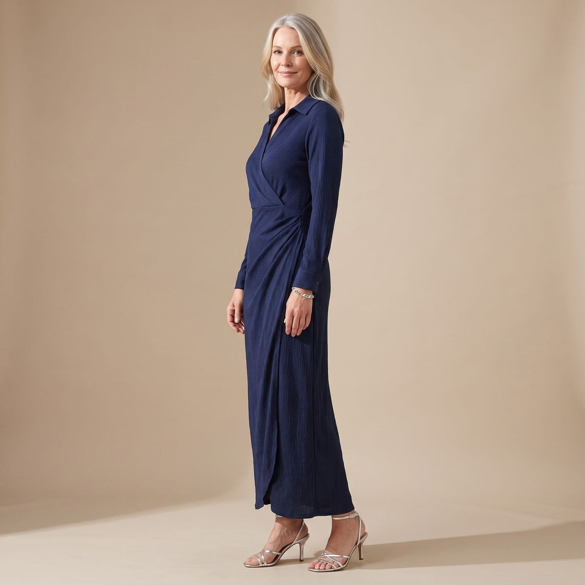 Vooraanzicht van de lange wikkeljurk met knopenlijst in marineblauw