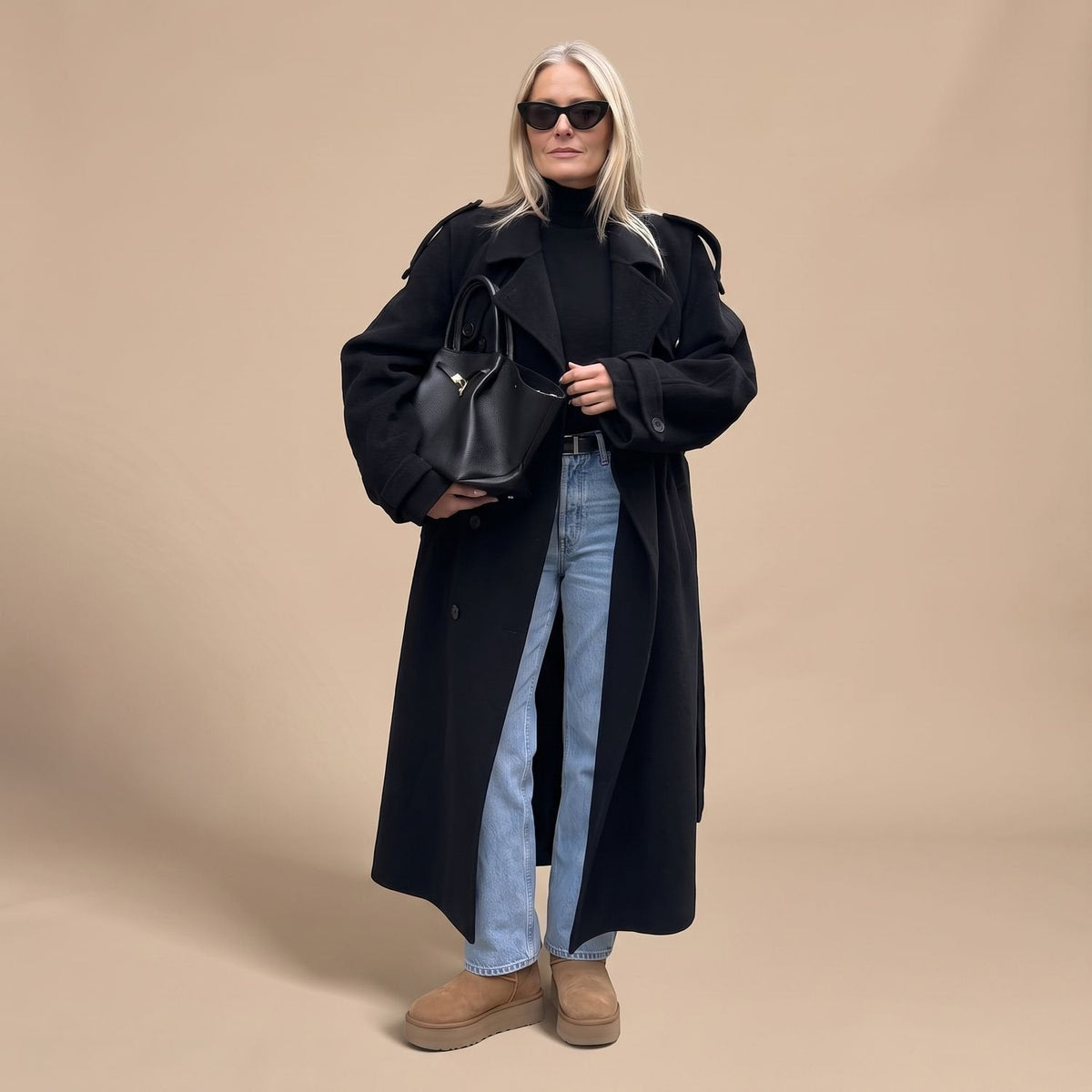 Achteraanzicht van de lange zwarte trenchcoat met ceintuur