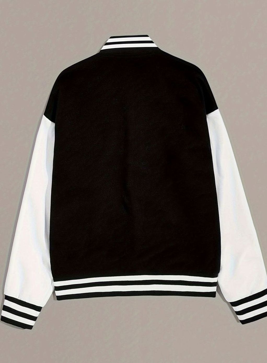Close-up van geborduurde letterpatch en drukknoopsluiting op varsity jack