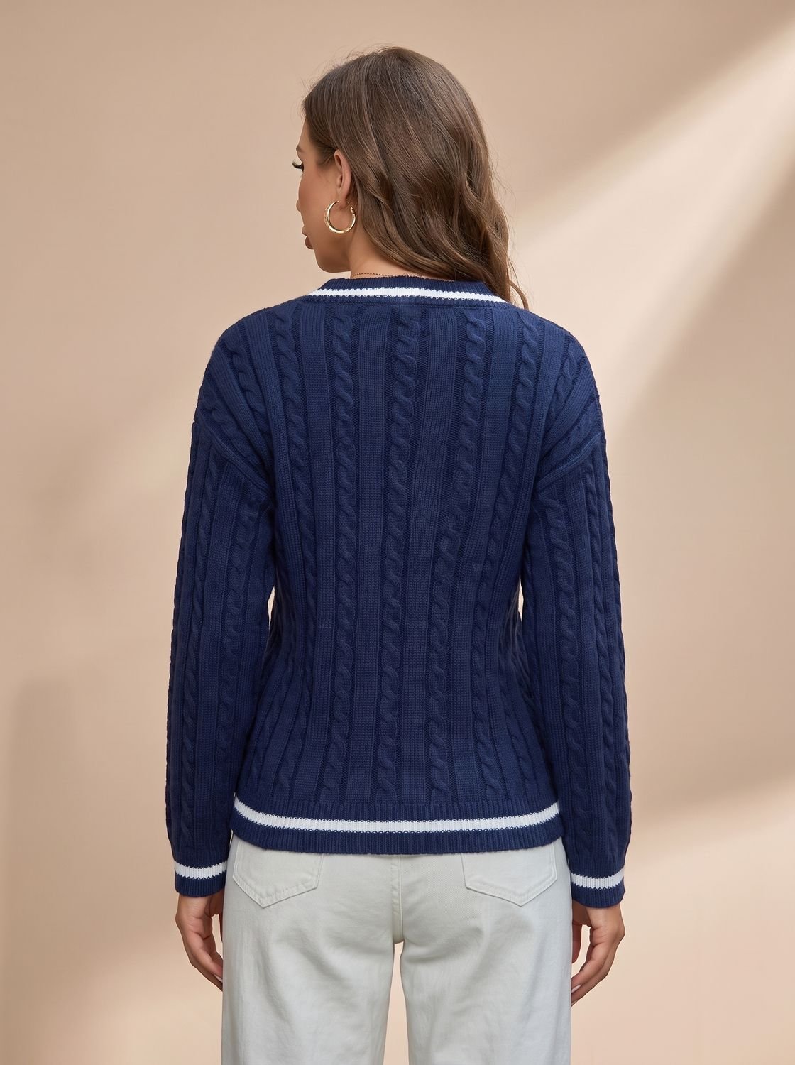 Dame draagt de kabeltrui gecombineerd met jeans voor casual look