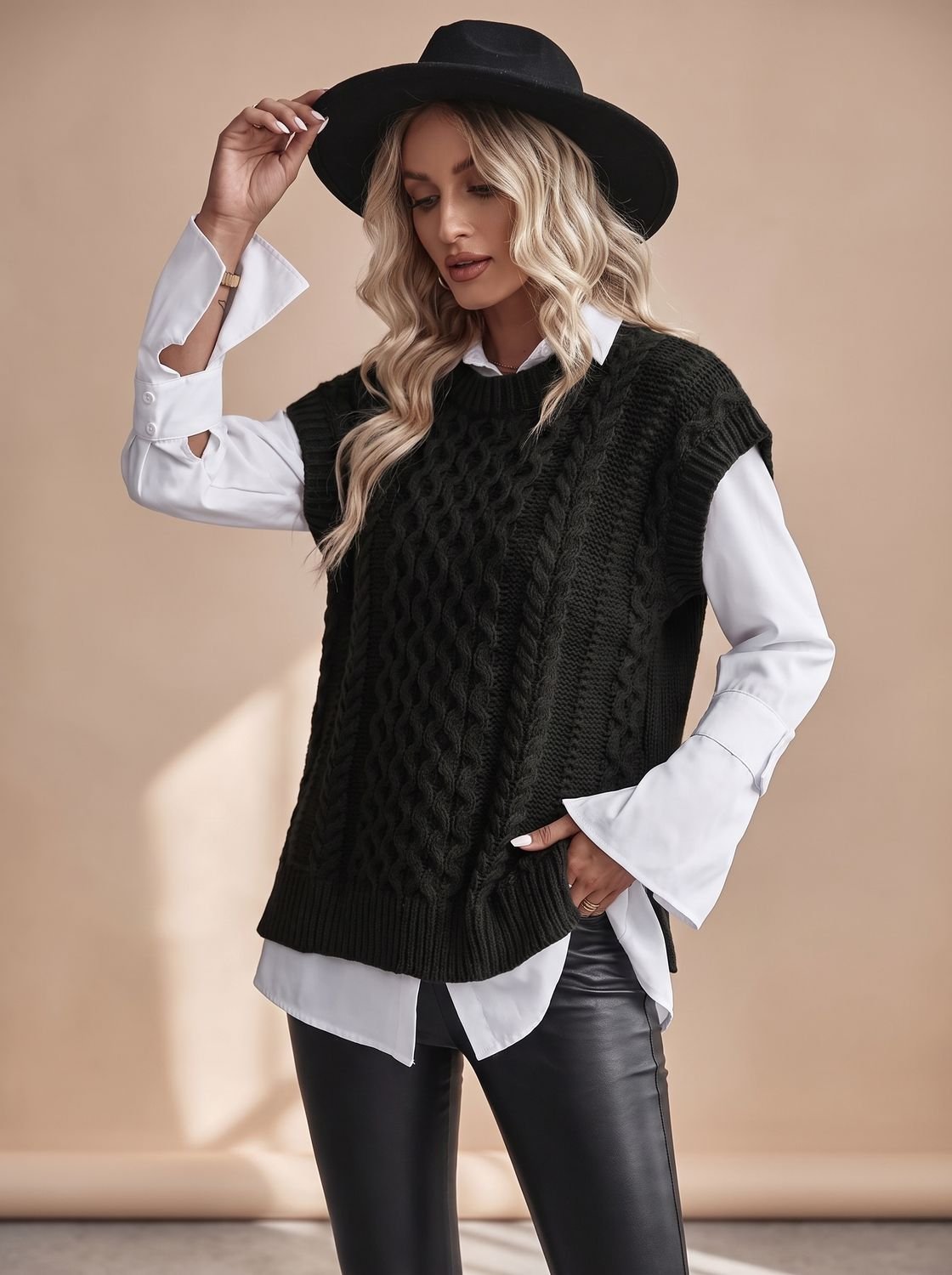 Model draagt kabelgebreid vest over coltrui