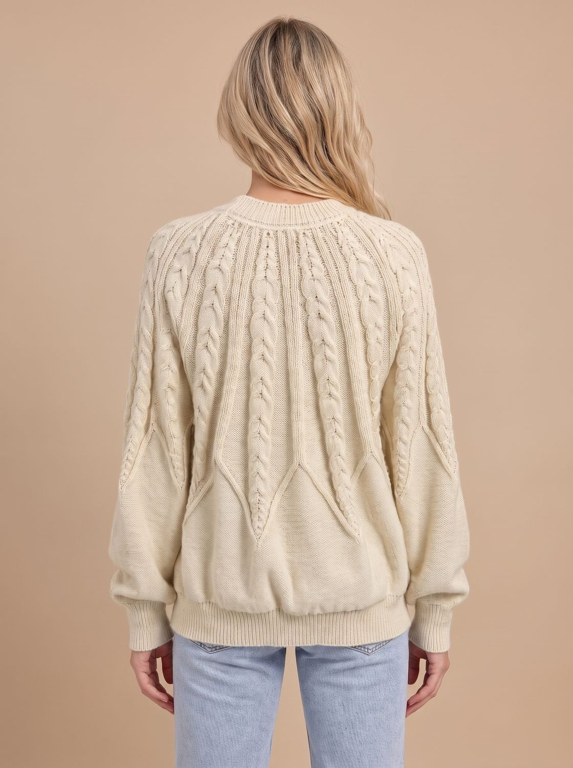 Model draagt de kabeltrui met jeans voor een casual look