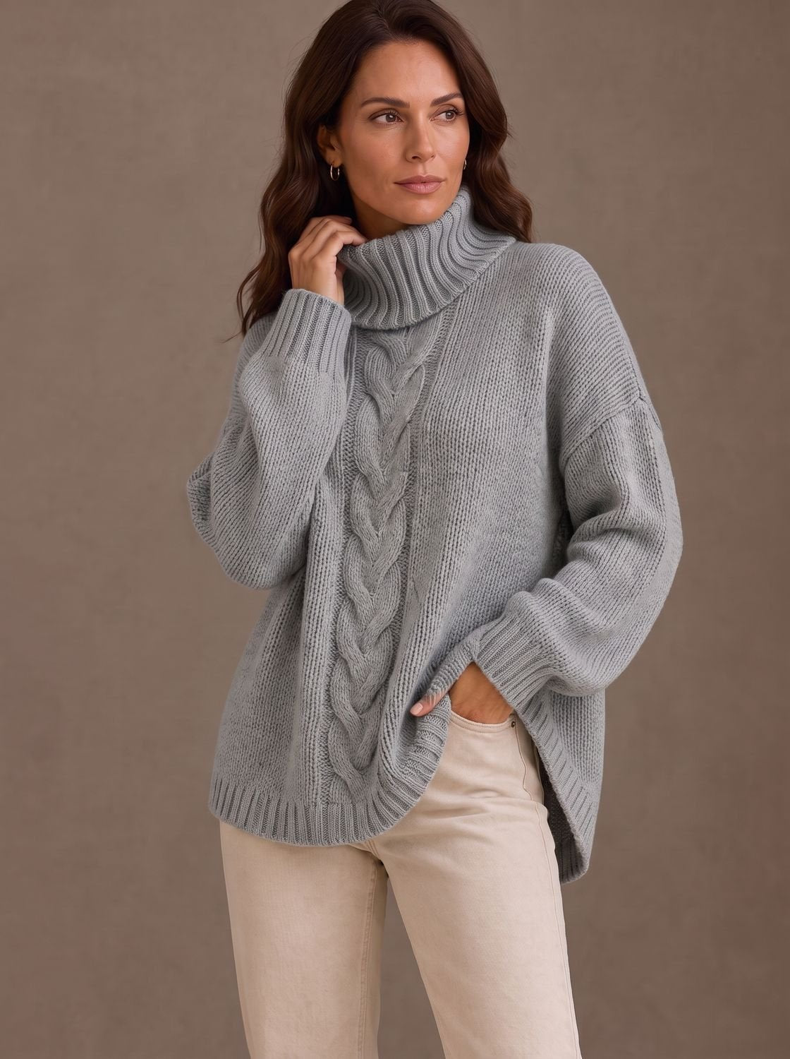 Dame draagt FENNORA oversized kabeltrui met jeans