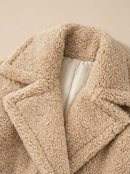 Dame draagt de beige teddy coat over een jurk voor een avondlook