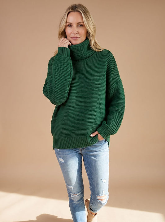 Dame draagt grofgebreide oversized coltrui in winterlook