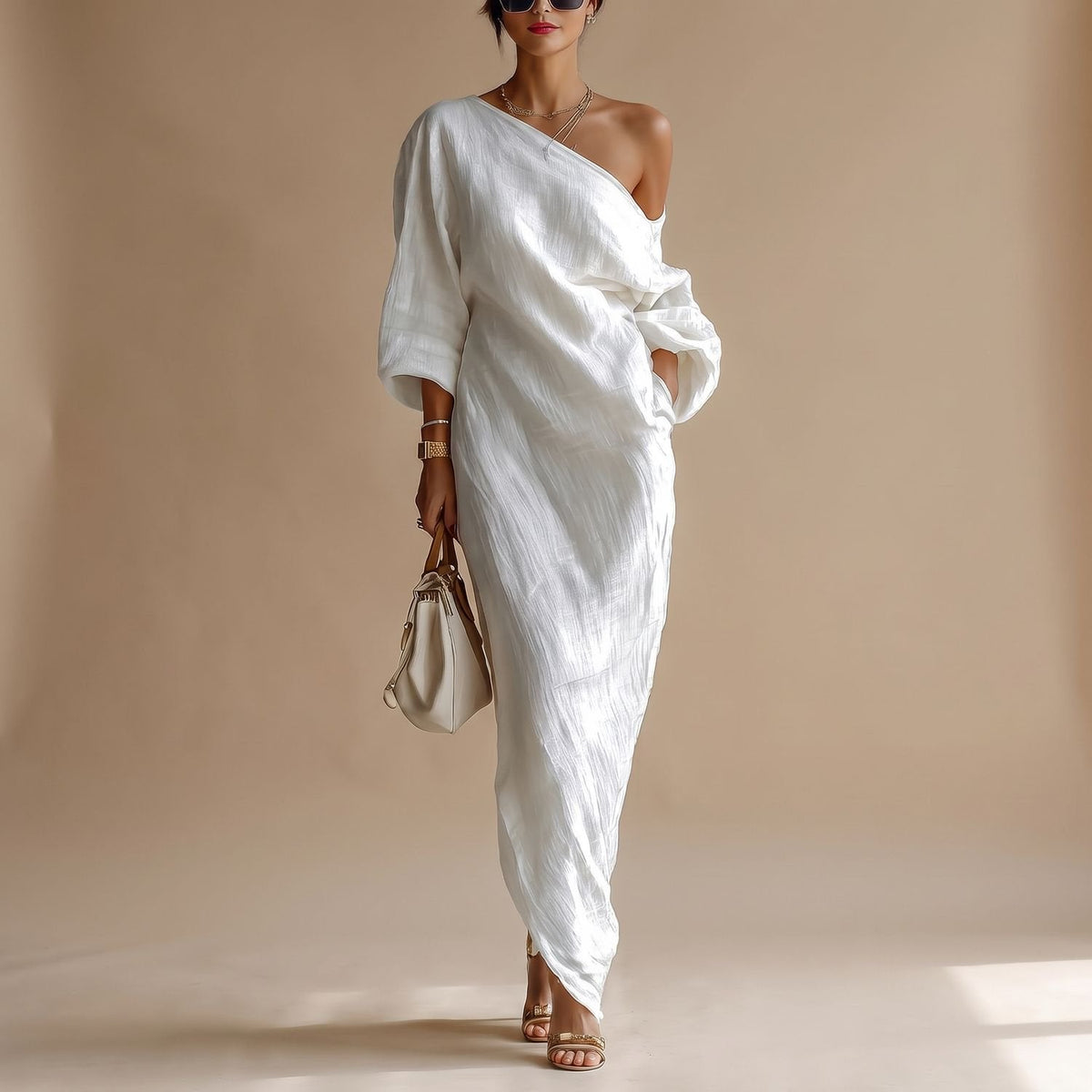 Vrouw draagt witte asymmetrische one-shoulder maxi-jurk met 3/4 mouwen