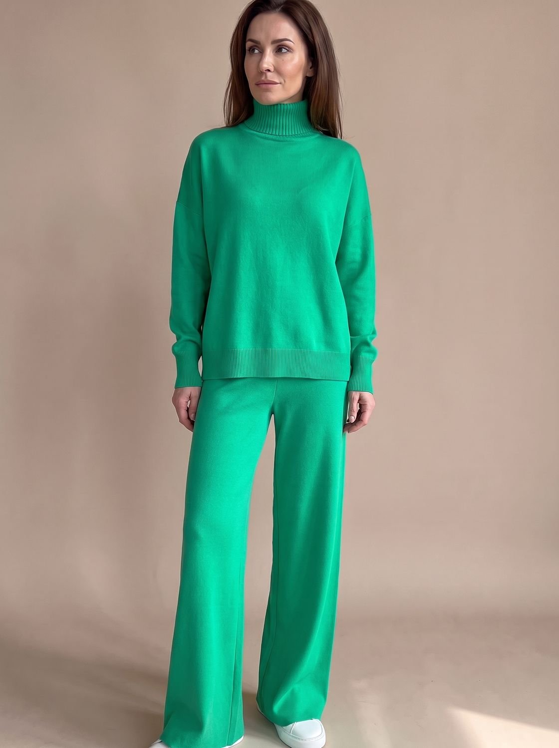 Model draagt de oversized rolkraagtrui gecombineerd met wijde broek