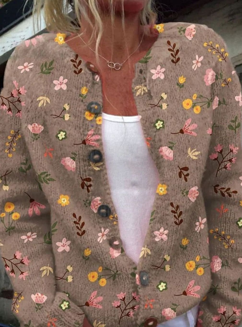 Detail van de knoopsluiting en lange mouwen van het vest
