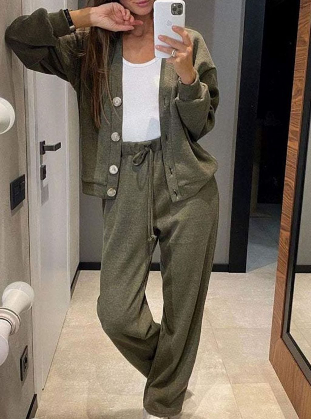 Vrouw draagt vest en broek set met knoopsluiting en wijde pijpen