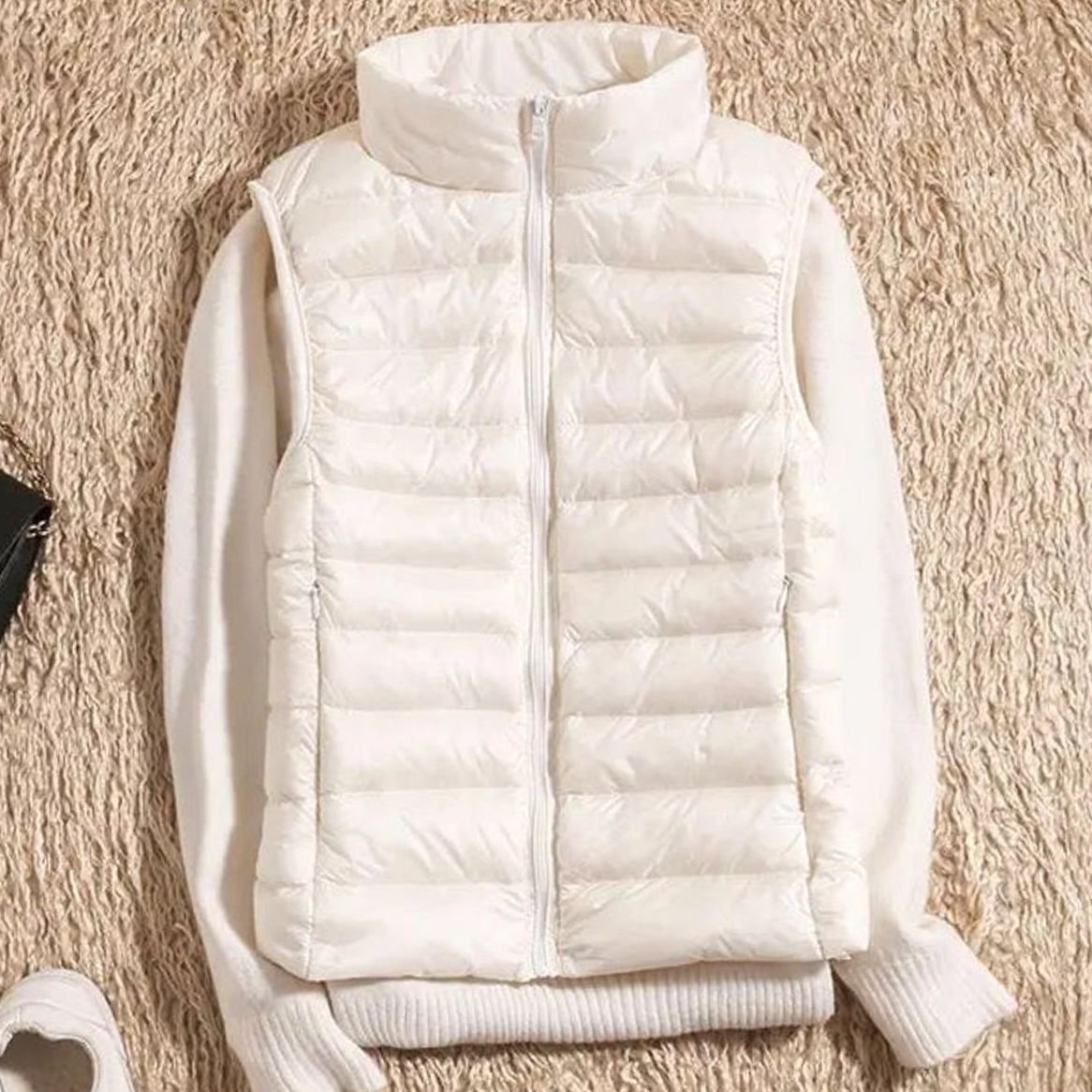 Detailfoto van de gewatteerde stof en naden van de QUENNA bodywarmer