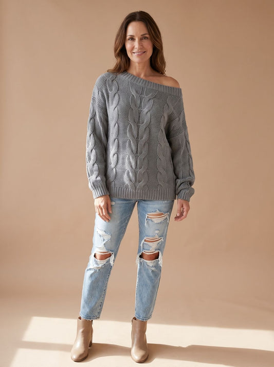 Dame draagt beige off-shoulder kabeltrui met relaxed fit