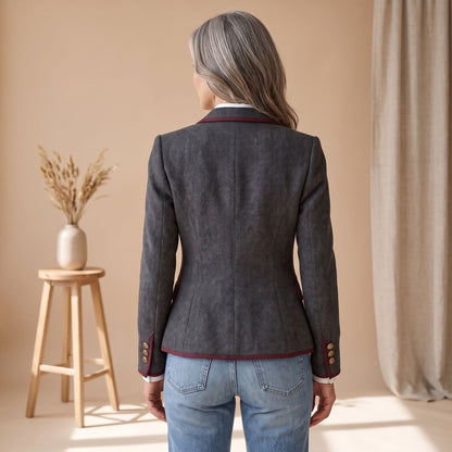Detail van de bordeauxrode paspel op de visgraat damesblazer